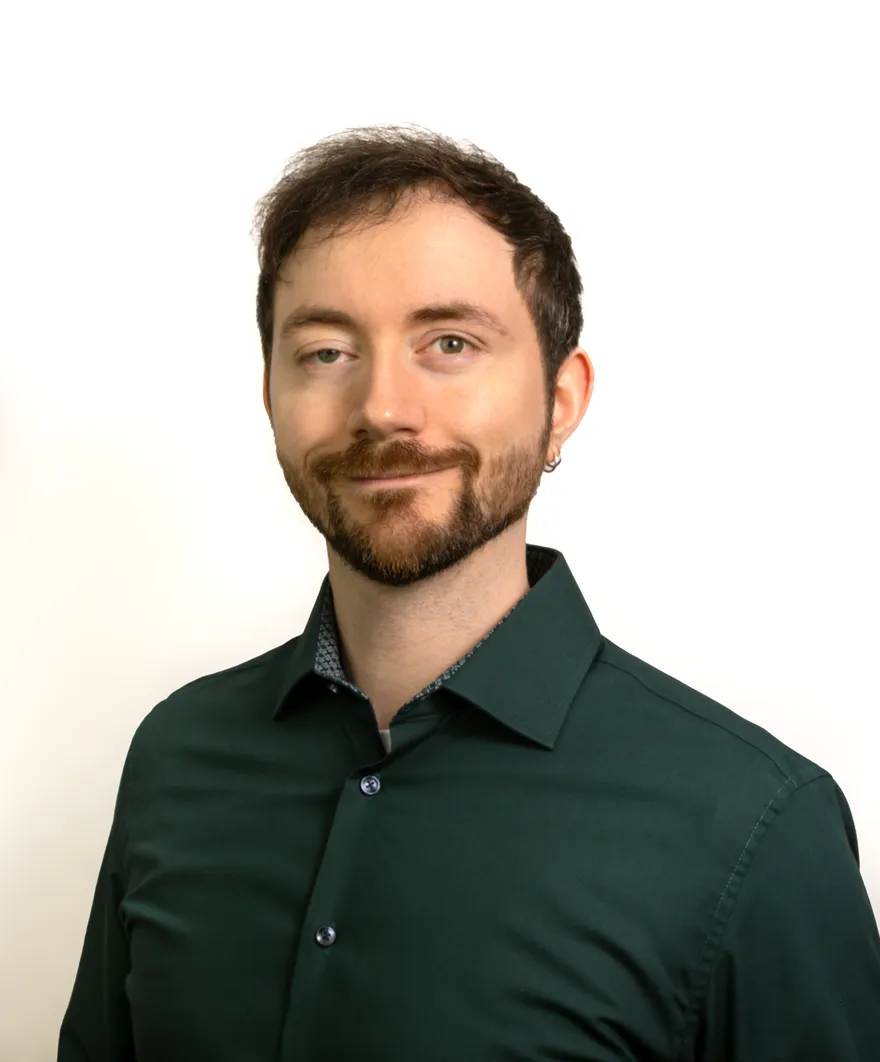 Portrait of Vincent Rubach in a dark green shirt, smiling.